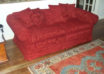 Red sofa with loose cover and cushions